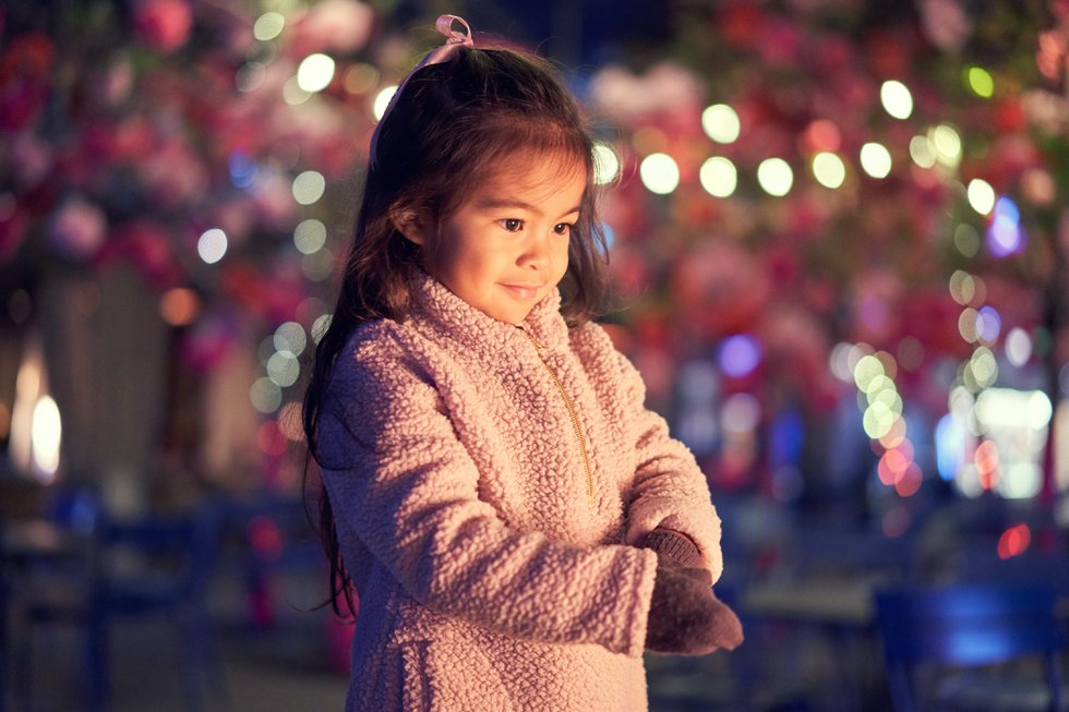 Little Girl Standing Near Christmas Lights